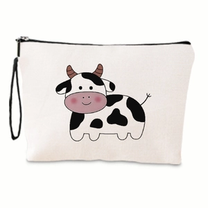 Dettaglio della trousse in tela bianca con stampa di mucca e cinturino da polso nero