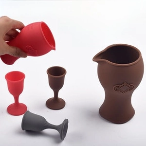 Close-up of flexible and durable silicone wine decanter and glasses being squeezed