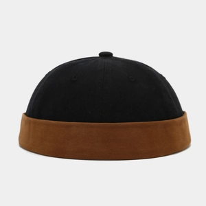 Detail of two-tone docker cap featuring black crown and brown brim in cotton twill fabric