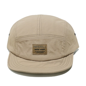 Detail of khaki five-panel camper hat with leather patch and metal eyelets on ripstop fabric