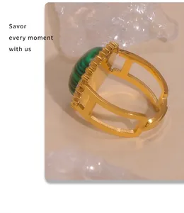 Detailed macro view of an open gold ring featuring a green oval stone and hollow band