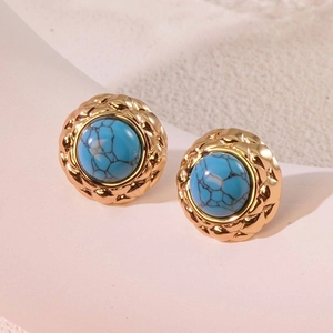 Detail of vintage gold button earring featuring blue stone with black marble texture