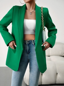 Détail d'un blazer vert vif pour femme avec une coupe minimaliste et professionnelle