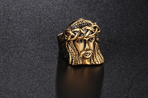 Macro shot of detailed golden Jesus head carving on vintage stainless steel ring
