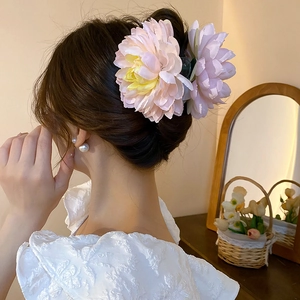 Detailed view of handmade fabric lotus flower hair claw clip on elegant hairstyle