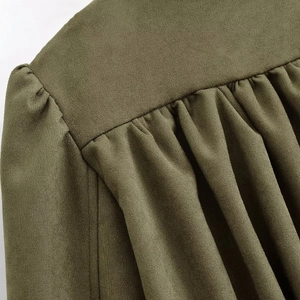 Detail of olive green suede jacket shoulder featuring pleated texture and fine stitching