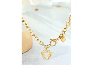 Detail of gold heart pendant necklace featuring OT toggle clasp and chunky chain link design