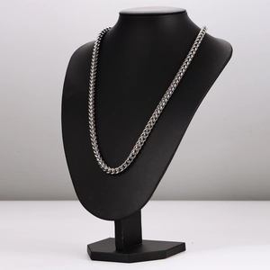 Silver stainless steel woven chain necklace displayed on a black neck bust model stand