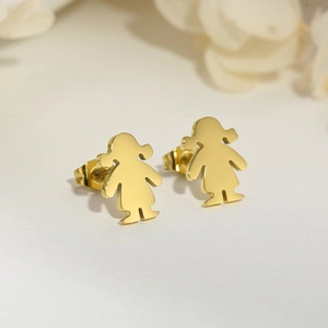 Macro shot of gold stainless steel cartoon girl stud earrings on floral background