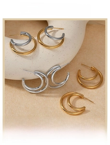 Detailed close-up of minimalist C-shaped double hoop earrings in gold and silver finishes