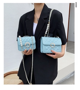 Detailed comparison of light blue quilted chain bags in medium and mini sizes with pearls