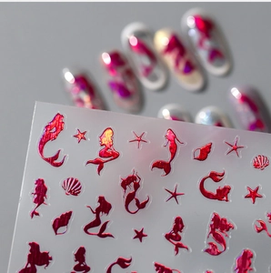 Macro view of metallic magenta mermaid and seashell laser nail stickers for 3D nail art