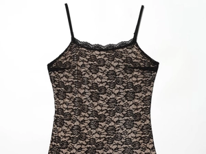 Dettaglio del motivo in pizzo nero su un abito bodycon sexy con spalline su sfondo bianco