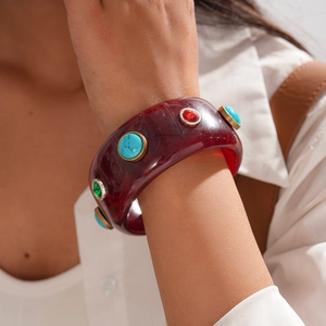 Detail of wide resin bangle with colorful stones and vintage gold metallic edges