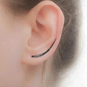 Minimalist black curved ear crawler earring shown on a model with elegant close-up detail