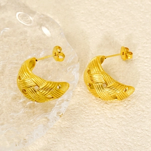Close-up of twisted moon-shaped stainless steel earrings with woven texture and gold finish