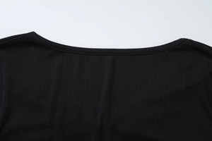 Detailaufnahme des schwarzen Rippstrickgewebes und der Nähte am Halsausschnitt