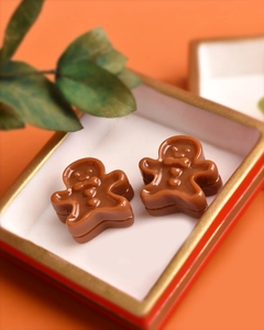 Miniature resin gingerbread man dolls on a red and gold ceramic plate for dollhouse decor