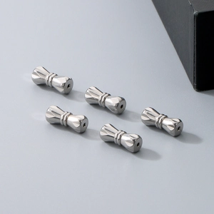 Close-up of five polished peanut-shaped screw clasps for DIY pearl necklace jewelry