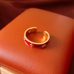 Detail of vintage 18k gold plated ring with red enamel and floral zircon inlay