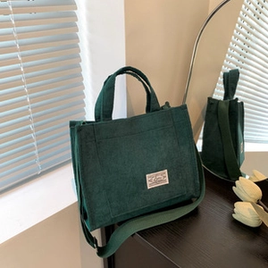 Vista dettagliata di una borsa tote in velluto a coste verde con tracolla regolabile