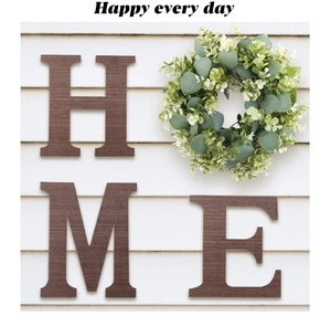 Detail of dark walnut wood H M E letters with green eucalyptus wreath wall decor
