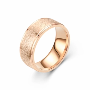 Détail d'une bague en acier or rose avec surface mate sablée et intérieur poli miroir
