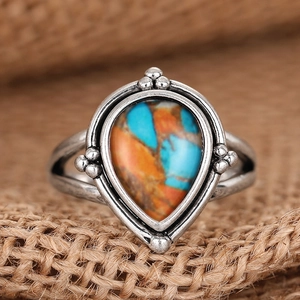 Vue détaillée d'une bague vintage argentée en goutte d'eau avec pierre colorée