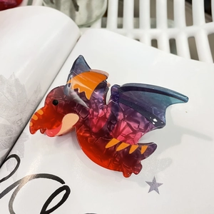 Colorful dinosaur pterosaur hair claw clip in acetate marble texture on white magazine