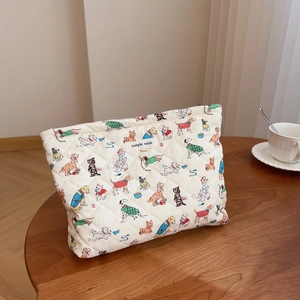 Quilted cotton makeup bag with cute dog patterns and a zipper closure on a wooden table