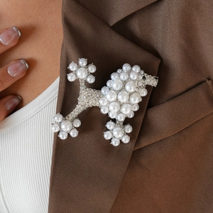 Elegant pearl and rhinestone poodle brooch pinned on a dark brown suit lapel