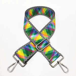 Detail of colorful geometric diamond pattern woven bag strap with silver metal hooks