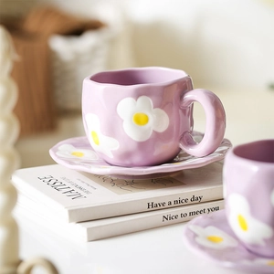 Detailed macro of a purple floral ceramic cup on books with soft ambient lighting