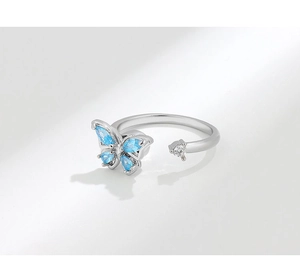 Close-up of silver rotating butterfly ring with blue and white crystals on open band