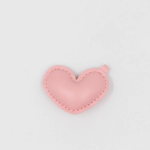 Close-up of a pink PU leather heart charm with neat stitching and small metal hanging loop