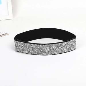 Close-up of sparkling silver sequins on black elastic waist belt with high texture detail