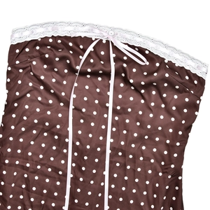 Close-up of brown polka dot satin fabric with delicate white lace trim and ribbon bow