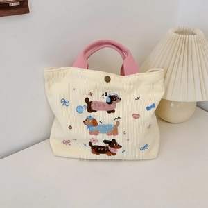 Détail de la broderie teckel et du bouton-pression en métal sur sac en velours