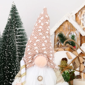 Detail of Christmas gnome with knit hat, white beard, pearl button and festive decor