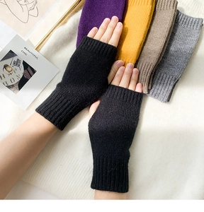 Flat lay of colorful knitted fingerless gloves in black, yellow, purple, and gray colors