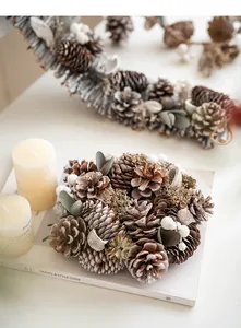 Detail of Christmas pine cone wreath with white berries on a minimalist magazine