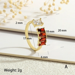 Macro shot of gold open ring with rectangular red and clear cubic zirconia stones