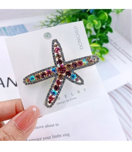 Close-up of alloy starfish hair clip with vibrant colorful rhinestones on a card