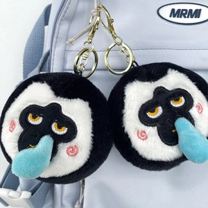 Close-up of cute plush monkey keychain with blue nose hanging on a blue backpack