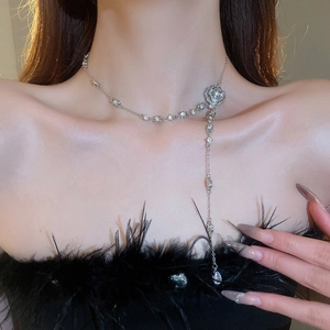 Detail of silver camellia flower pendant necklace with diamonds and long tassels