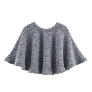 Détail d'une cape en maille crochetée grise avec ourlet volanté sur fond blanc