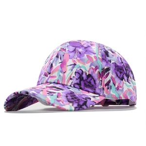 Tie-dye cotton baseball cap with purple floral pattern and curved brim in 45-degree view