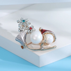 Macro view of Christmas snowman brooch with pearls, red enamel hat and inlaid crystals