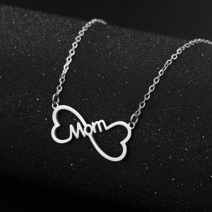 Polished silver stainless steel MOM heart pendant necklace on dark sparkling background