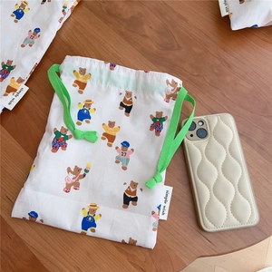 Close-up of drawstring cotton storage bag with cute cartoon bears and green cord